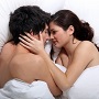 couple heureux s'embrassant allongé dans un lit