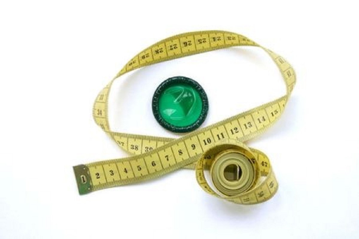 preservatif de couleur vert posé à coté d'un mètre de tailleur